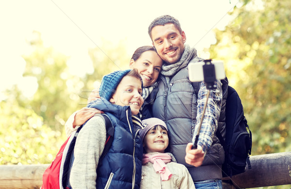 Stock photo: happy family with smartphone selfie stick in woods