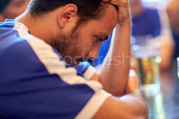 close up of sad football fan at bar or pub Stock photo © dolgachov