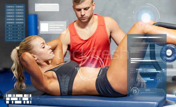 woman with personal trainer doing sit ups in gym Stock photo © dolgachov