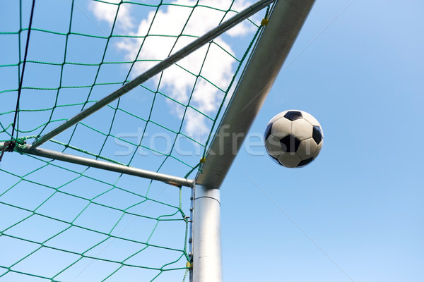 soccer ball flying into football goal net over sky Stock photo © dolgachov