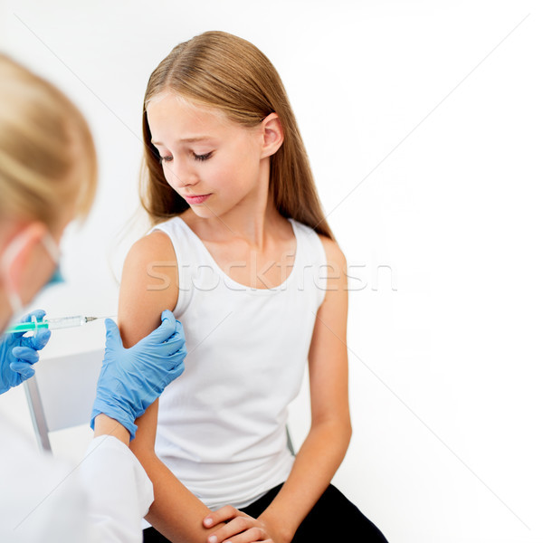 doctor with syringe making injection to girl Stock photo © dolgachov