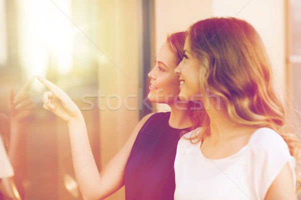happy young women pointing finger to shop window Stock photo © dolgachov
