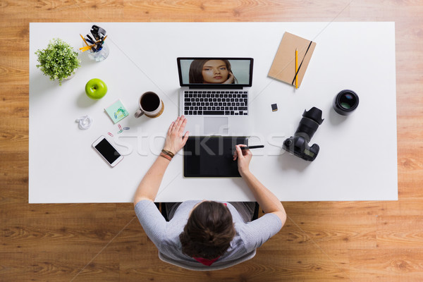 woman with camera working on laptop at table Stock photo © dolgachov