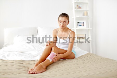 woman with feather touching bare legs on bed Stock photo © dolgachov