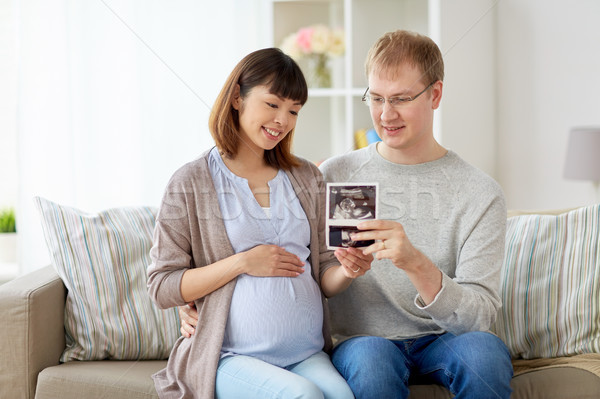 happy couple with ultrasound images at home Stock photo © dolgachov