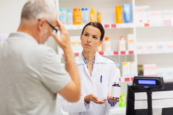 apothecary showing drug to senior man at pharmacy Stock photo © dolgachov