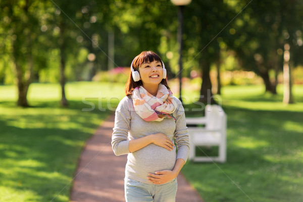 Foto stock: Feliz · grávida · asiático · mulher · fones · de · ouvido · parque