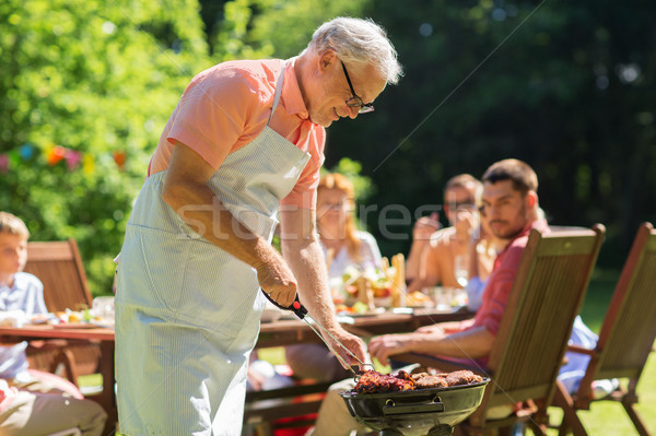 senior man cooking meat on barbecue grill outdoors Stock photo © dolgachov