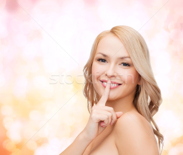 beautiful young woman pointing finger to lips Stock photo © dolgachov
