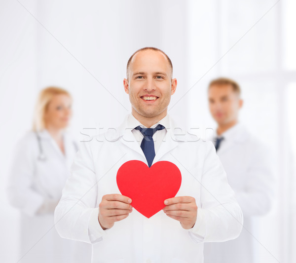 smiling male doctor with red heart Stock photo © dolgachov