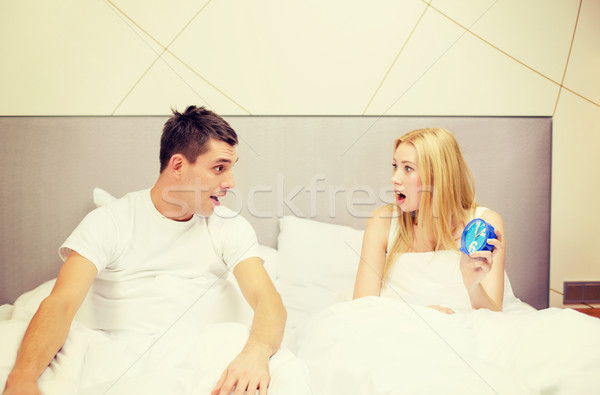 surprised couple with clock in bed Stock photo © dolgachov