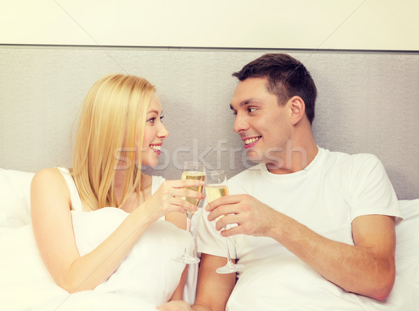 smiling couple with champagne glasses in bed Stock photo © dolgachov
