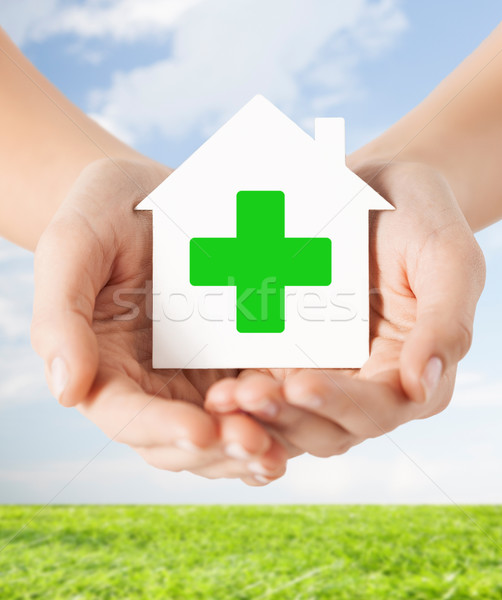 Stock photo: hands holding paper house with green cross