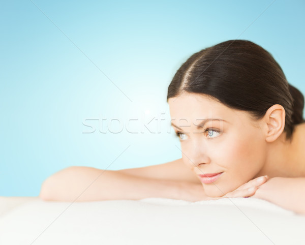 happy beautiful woman lying on massage desk at spa Stock photo © dolgachov