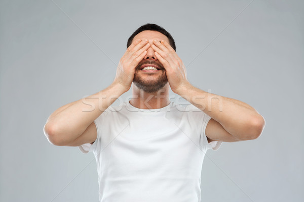 smiling man closing his eyes over gray background Stock photo © dolgachov