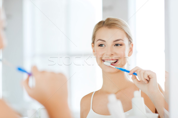 Mulher escova de dentes limpeza dentes banheiro Foto stock © dolgachov