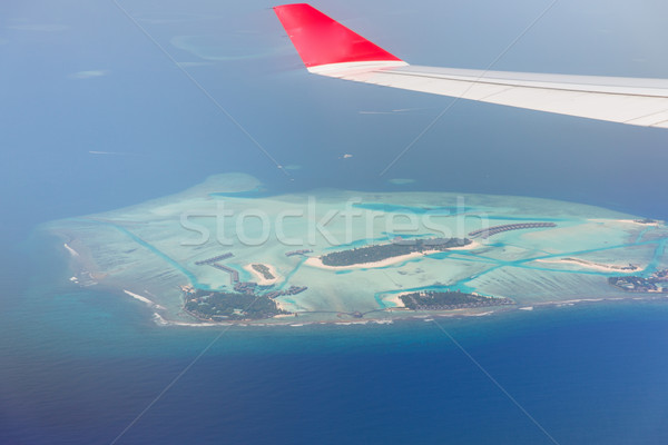 close up of airplane wing above island in ocean Stock photo © dolgachov