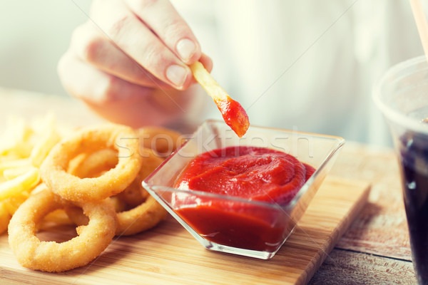 close up of hand dipping french fries into ketchup Stock photo © dolgachov