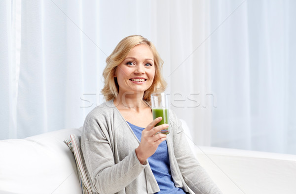happy woman drinking green juice or shake at home Stock photo © dolgachov