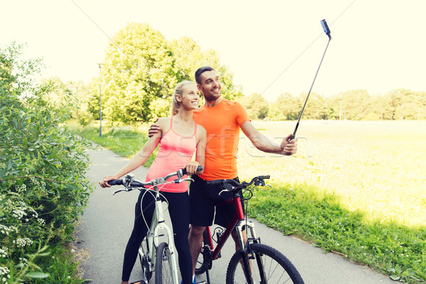 couple with bicycle and smartphone selfie stick Stock photo © dolgachov