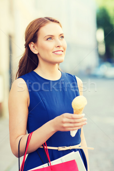 Stock photo: woman with shopping bags and ice cream in city