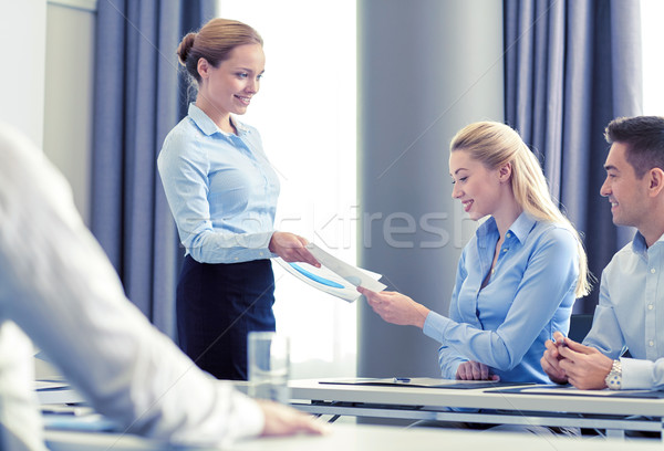 woman giving papers to group of businessmen Stock photo © dolgachov