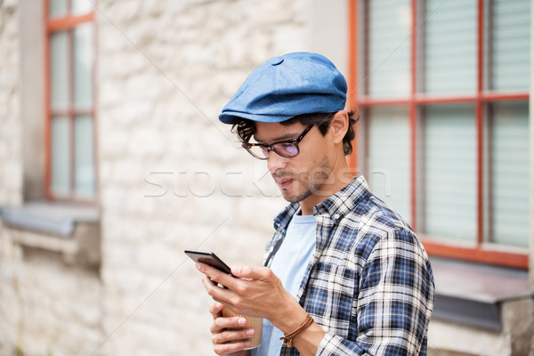 man with smartphone drinking coffee on city street Stock photo © dolgachov
