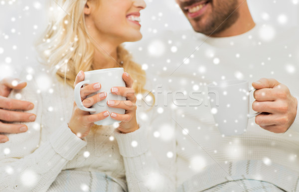 close up of happy couple with tea cups at home Stock photo © dolgachov