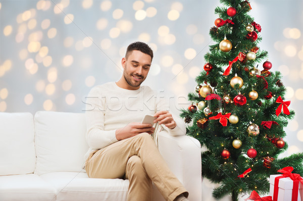 smiling man with smartphone for christmas Stock photo © dolgachov