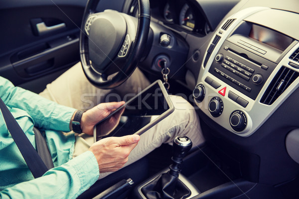 Stock photo: close up of young man with tablet pc driving car