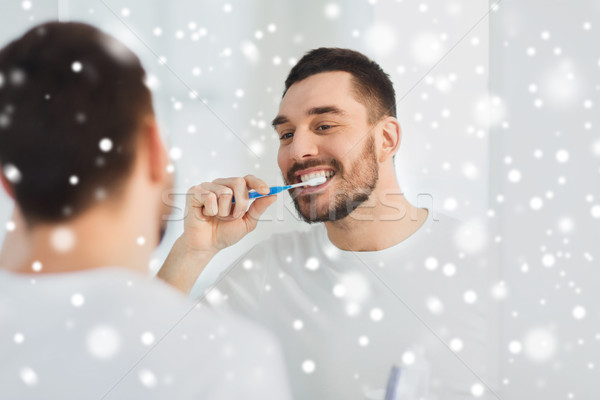 Homem escova de dentes limpeza dentes banheiro atendimento odontológico Foto stock © dolgachov