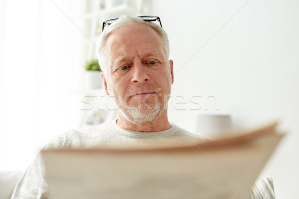 close up of senior man reading newspaper at home Stock photo © dolgachov