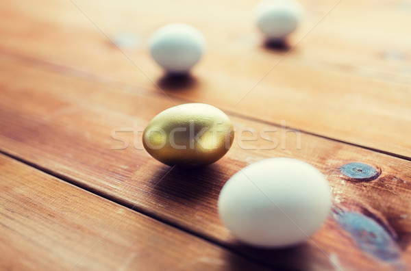 close up of golden and white easter eggs on wood Stock photo © dolgachov