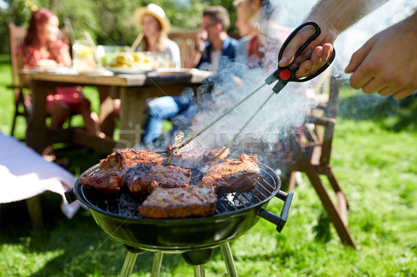 Stock photo: man cooking meat on barbecue grill at summer party