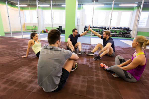 group of happy friends making high five in gym Stock photo © dolgachov