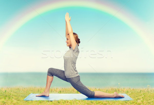 happy woman making yoga in low lunge on mat Stock photo © dolgachov