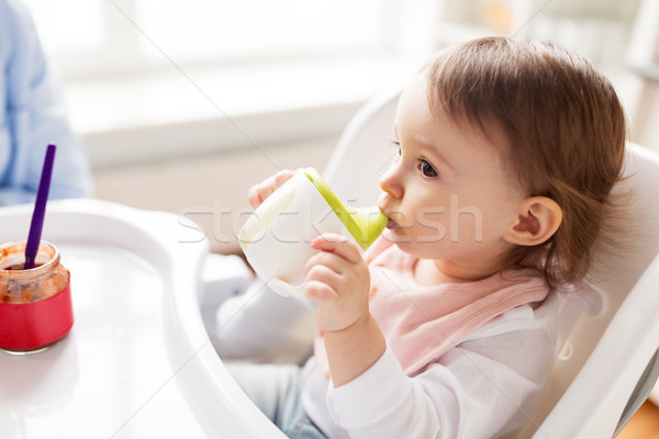 baby drinking from spout cup in highchair at home Stock photo © dolgachov