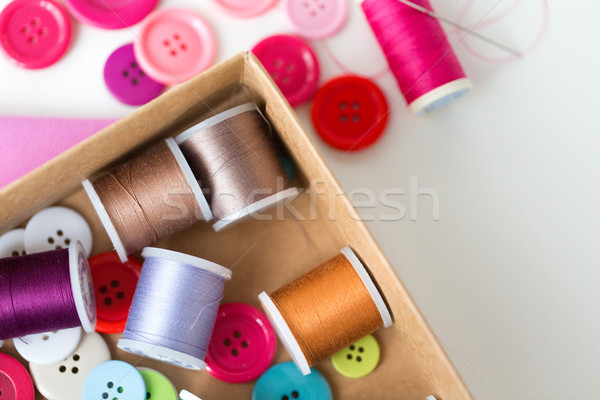 box with thread spools and sewing buttons on table Stock photo © dolgachov