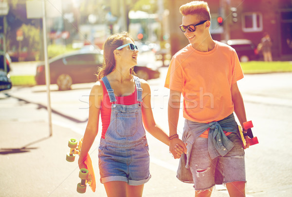 teenage couple with skateboards on city street Stock photo © dolgachov