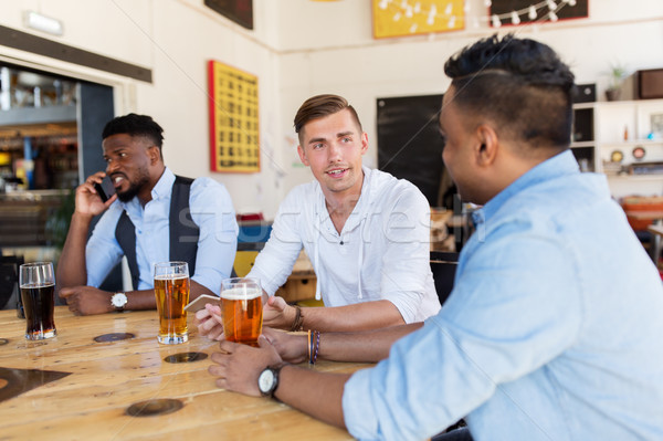 Fericit masculin prietenii potabilă bere bar Imagine de stoc © dolgachov