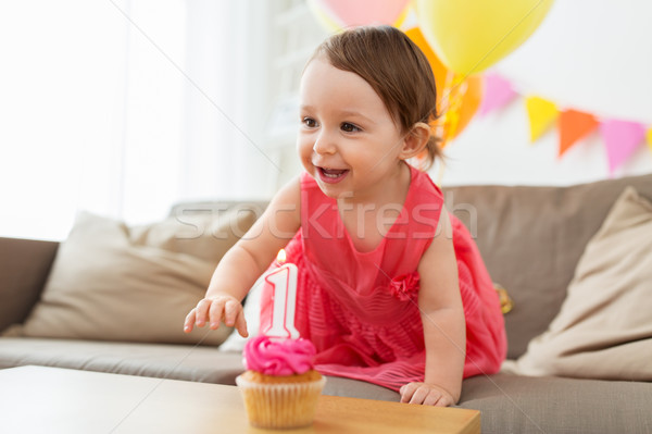 baby girl with birthday cupcake at home party Stock photo © dolgachov