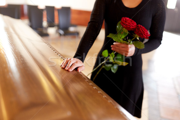 woman with red roses and coffin at funeral Stock photo © dolgachov