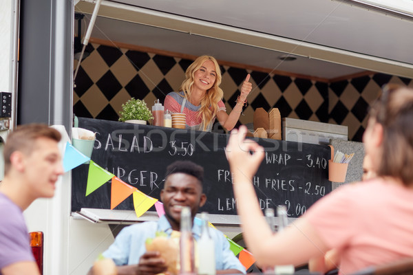 happy saleswoman showing thumbs up at food truck Stock photo © dolgachov