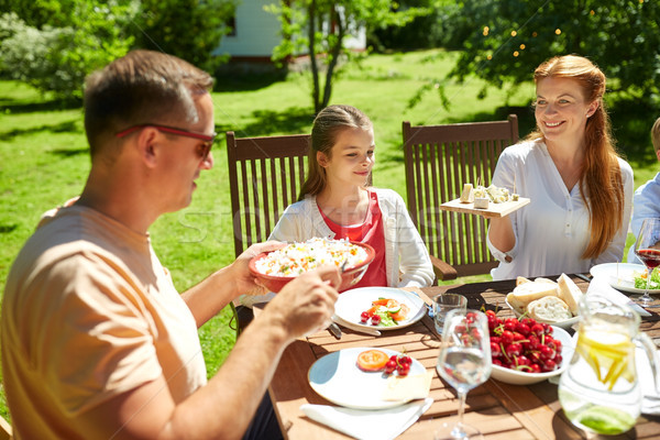 счастливая семья обеда лет прием гостей в саду отдыха праздников Сток-фото © dolgachov