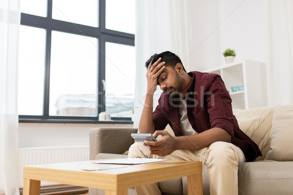 upset man with papers and calculator at home Stock photo © dolgachov