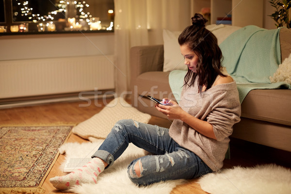 happy young woman with smartphone at home Stock photo © dolgachov