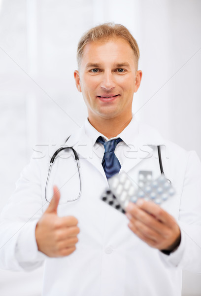 young male doctor with packs of pills Stock photo © dolgachov