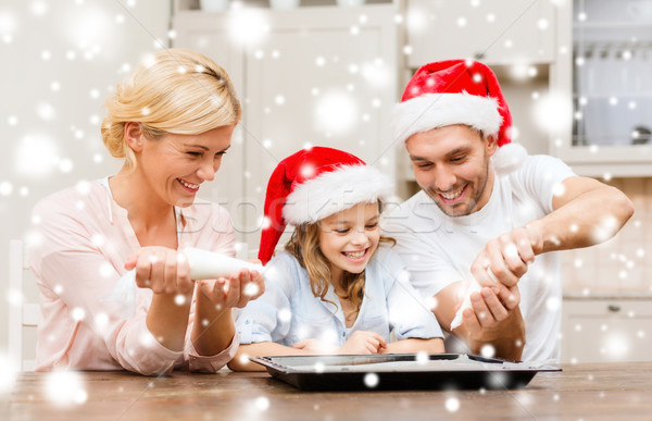 happy family in santa helper hats making cookies Stock photo © dolgachov