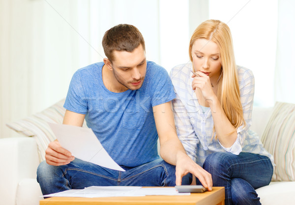 Stock photo: busy couple with papers and calculator at home