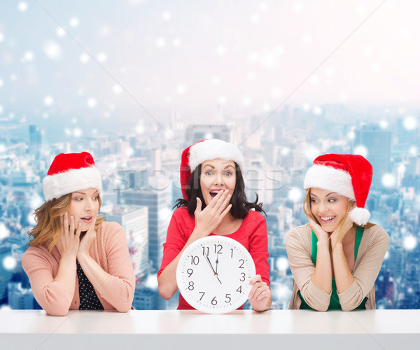 smiling women in santa helper hats with clock Stock photo © dolgachov